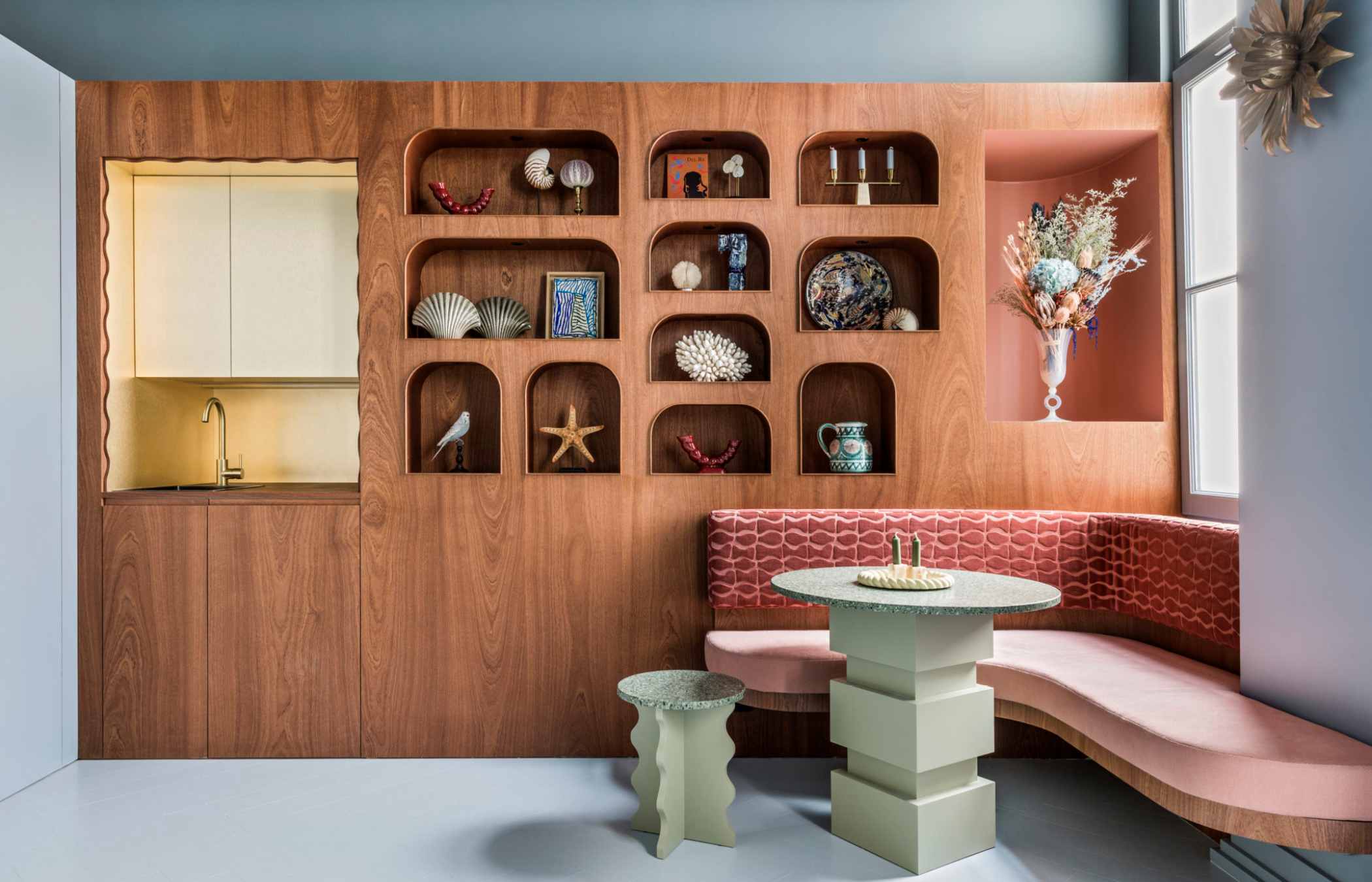Mini Hôtel Rue du Bac par Batiik Studio - salon banquette rose et étagères intégrées bois